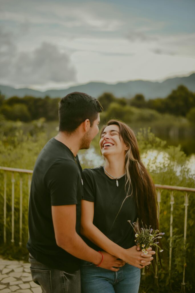 Happy couple laughing and holding flowers in San Cristóbal de las Casas, Mexico. Romantic outdoor setting.